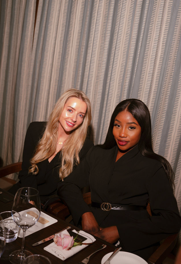 Two women seated together at an intimate dinner